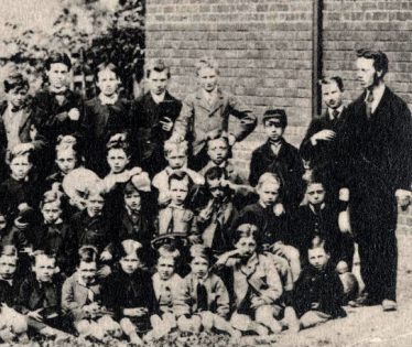 Mr Chote, the headmaster, right. (Sir) William Gentle, pupil centre back holding book. Mr Chote, the headmaster, right. (Sir) William Gentle, pupil centre back holding book. | From an Ashwell Merchant Taylors School photo of the 1870's