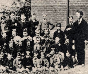 Mr Chote, the headmaster, right. (Sir) William Gentle, pupil centre back holding book. | From an Ashwell Merchant Taylors School photo of the 1870's